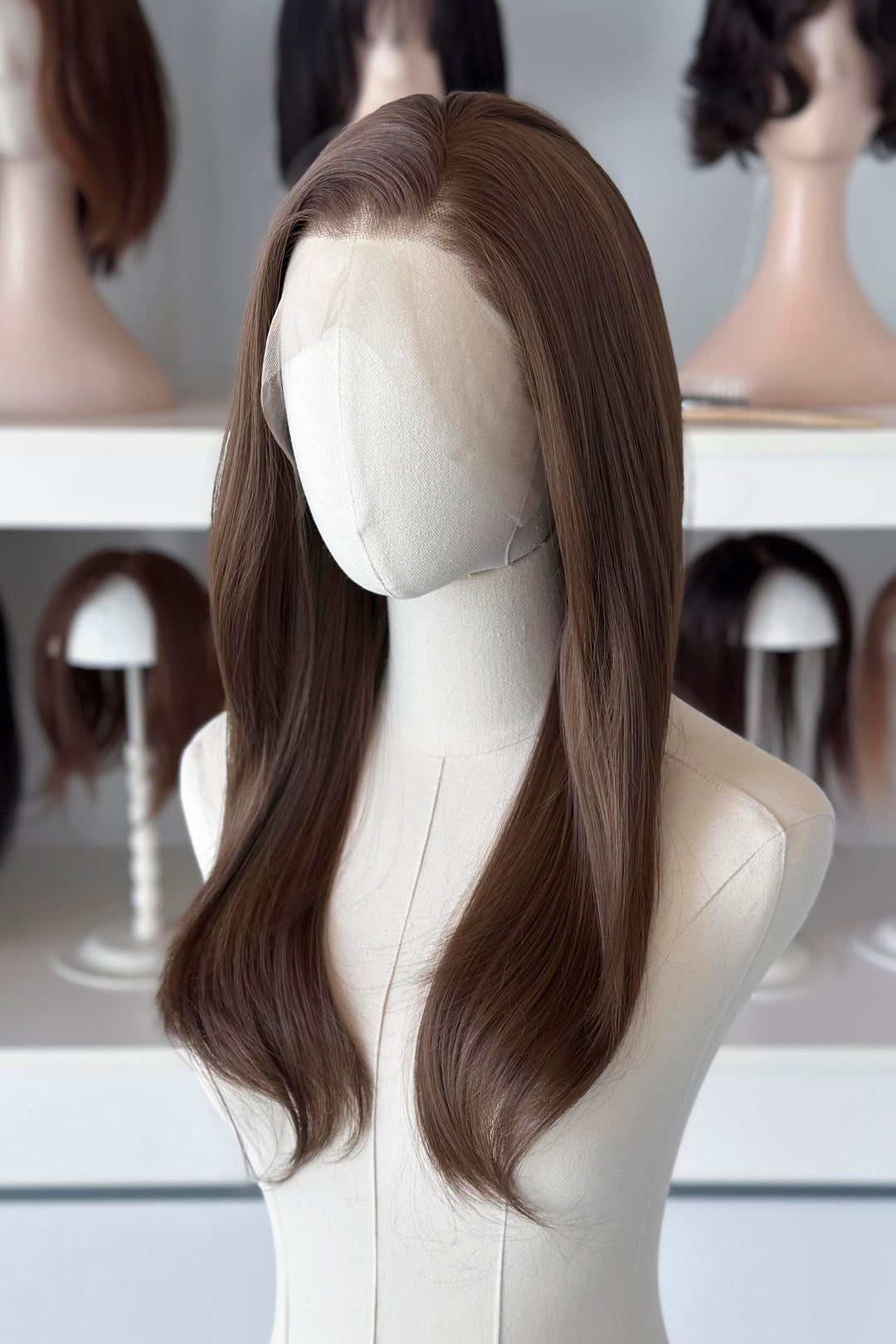 18" straight natural brown lace front wig display in a wig shop.
