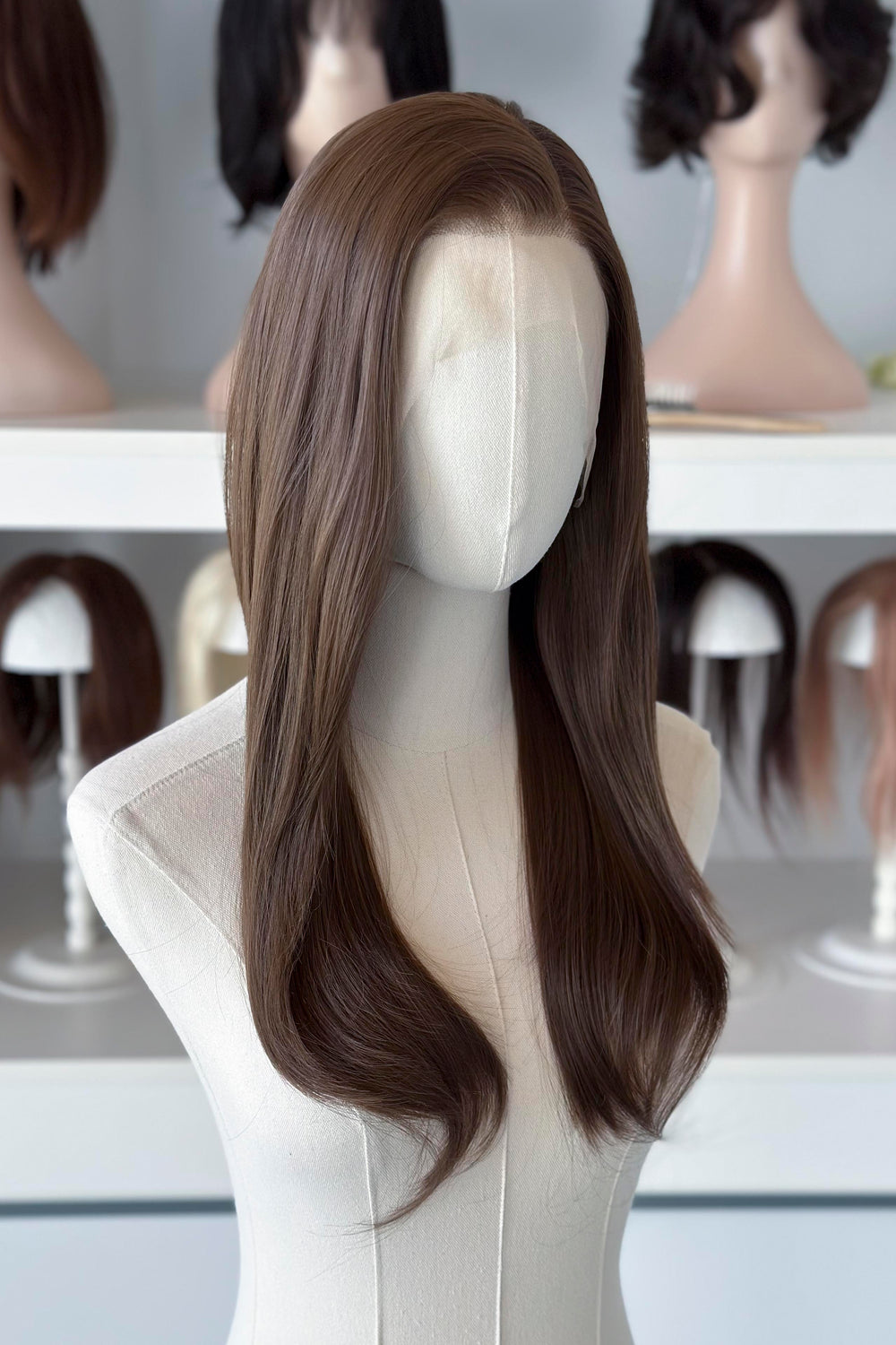 18" straight natural brown lace front wig display in a wig shop.