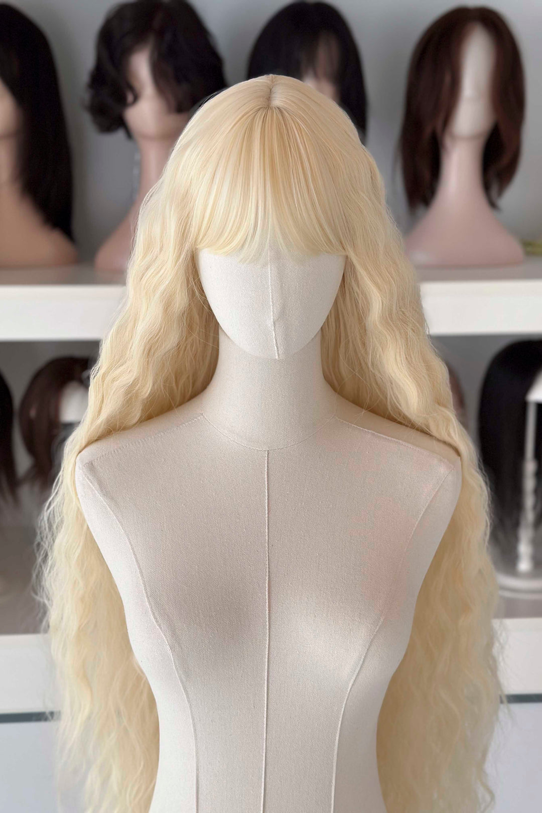 Back and front view of 40 inch extra long icy platinum blonde wavy wig with bangs on a mannequin.
