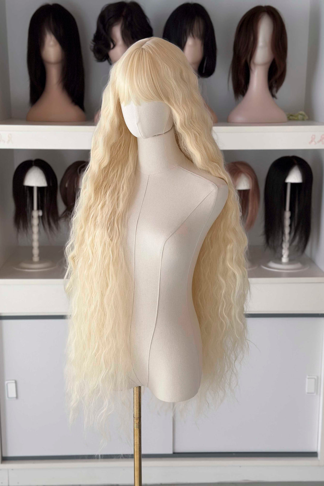 Back and front view of 40 inch extra long icy platinum blonde wavy wig with bangs on a mannequin.