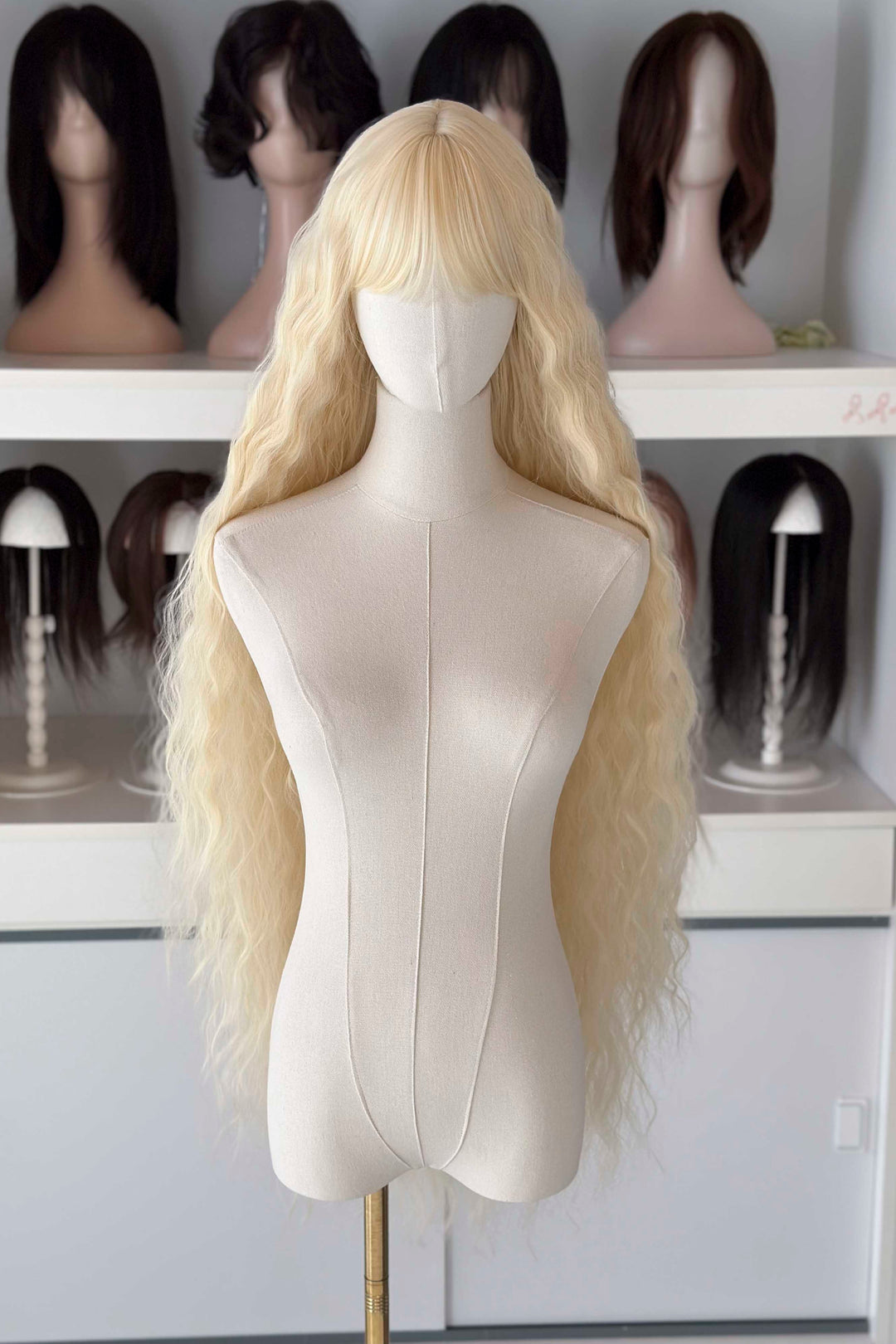 Back and front view of 40 inch extra long icy platinum blonde wavy wig with bangs on a mannequin.