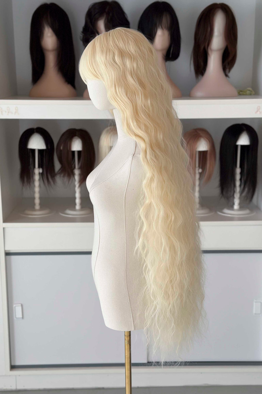 Back and front view of 40 inch extra long icy platinum blonde wavy wig with bangs on a mannequin.