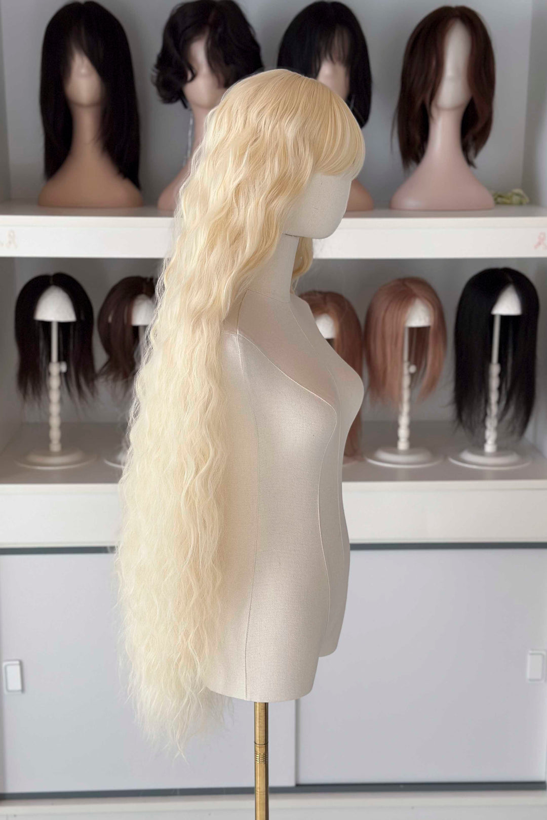 Back and front view of 40 inch extra long icy platinum blonde wavy wig with bangs on a mannequin.