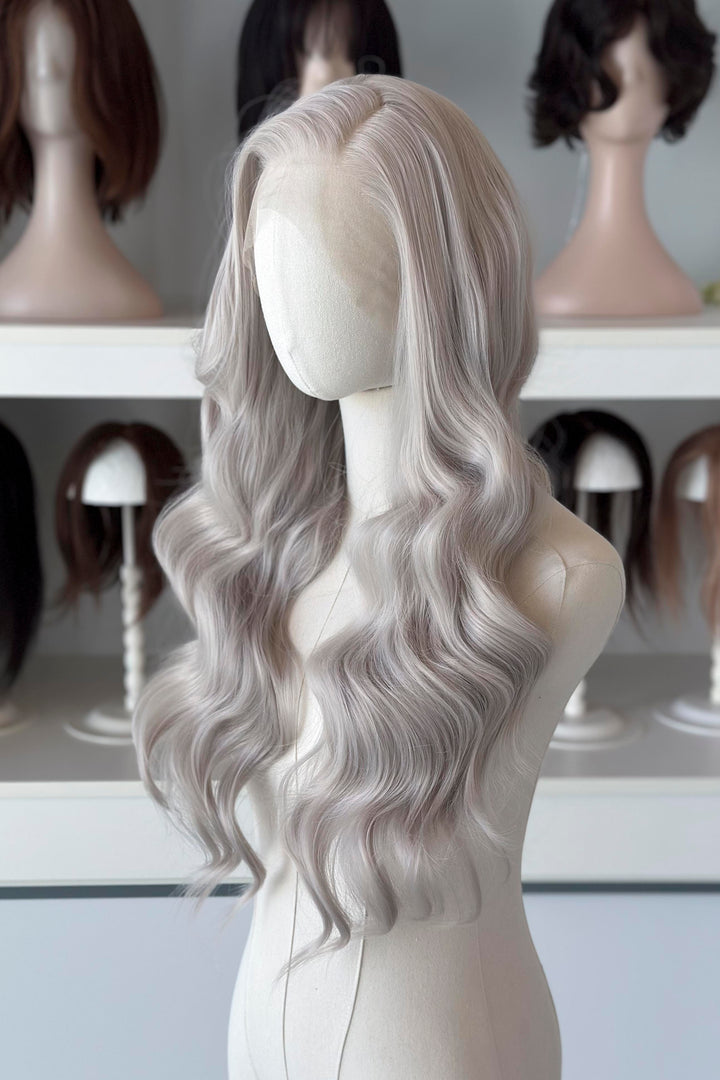 Silver lace front wig on a mannequin head with blurred wig display in the background