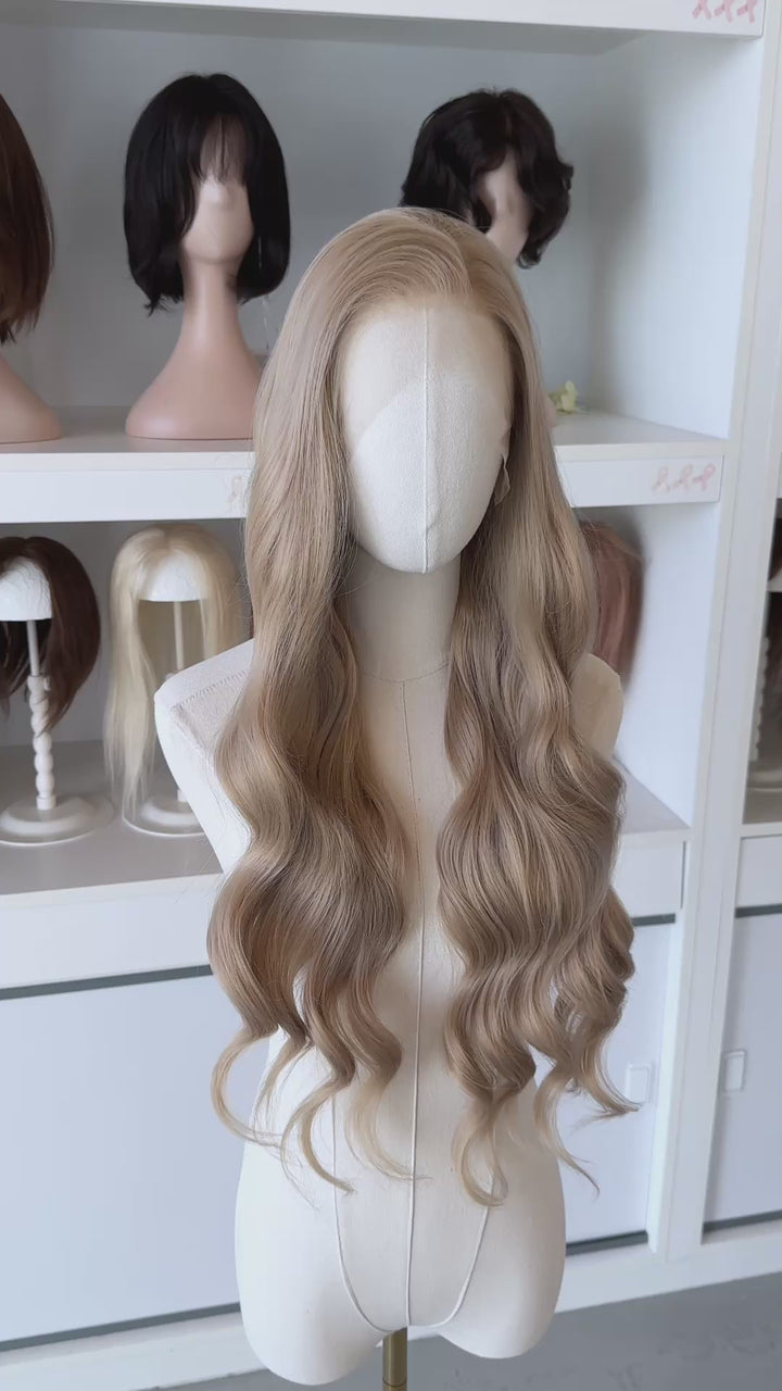 Light Golden Blonde wig on a mannequin head with blurred wig mannequins in the background, good for Aelin Galathynius cosplay