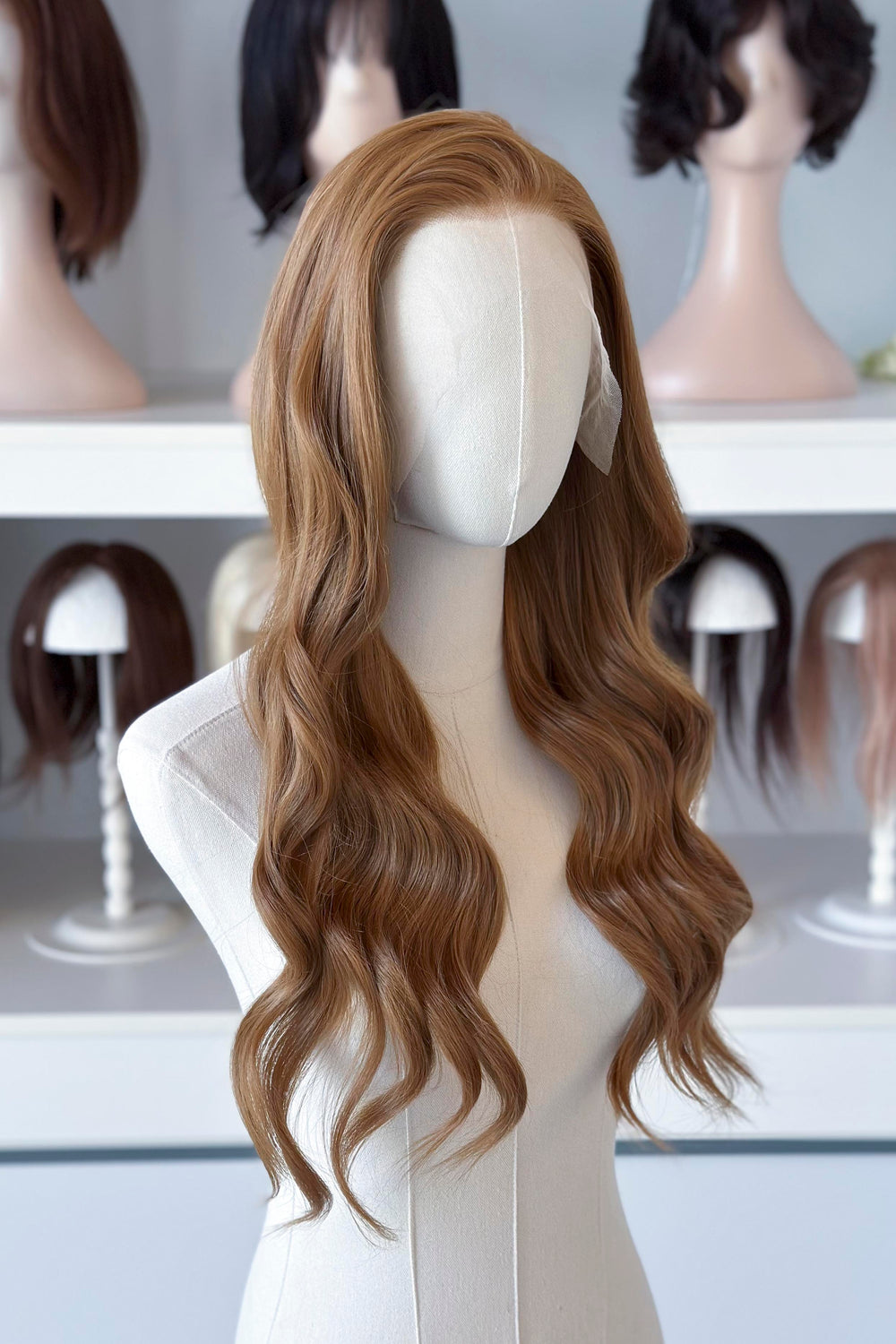  a long, wavy copper brown blonde wig in a wig store setting.